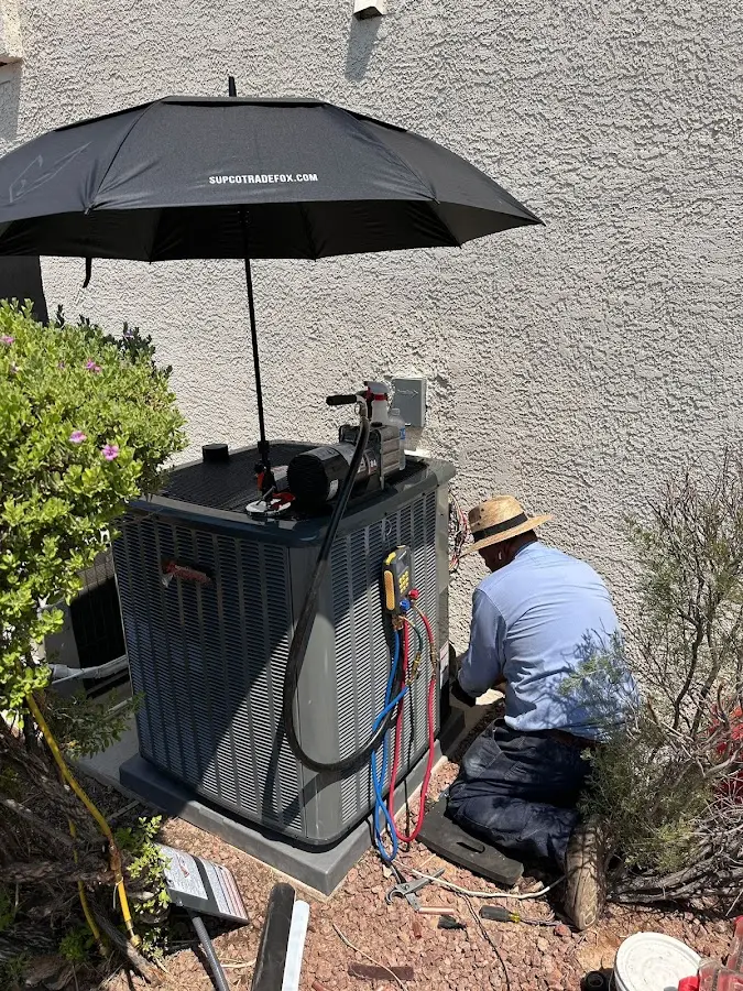 HVAC technician performing outdoor AC maintenance in Leesburg