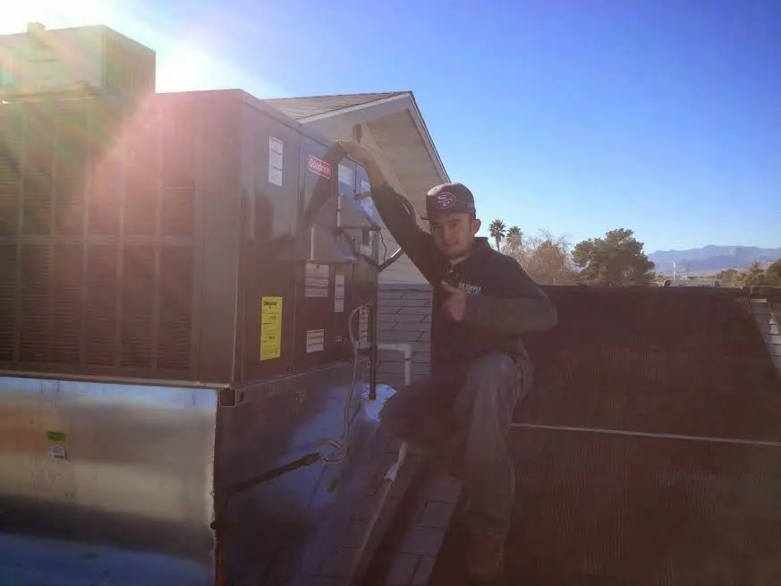 HVAC technician performing Air Duct Repair on a rooftop unit in Leesburg